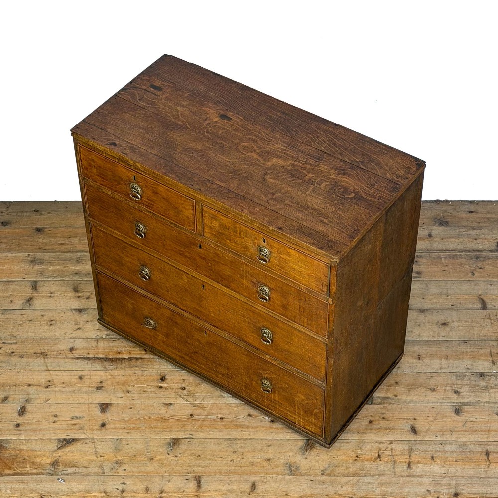 A nineteenth-century oak chest of drawers featuring two short over three long drawers with brass ring handles. View IX