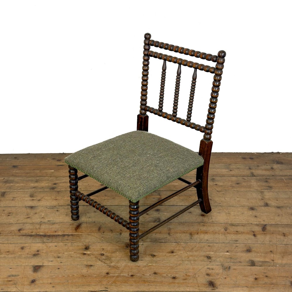 A Victorian bobbin-turned dark timber side chair featuring a textured green wool tweed upholstered seat.
