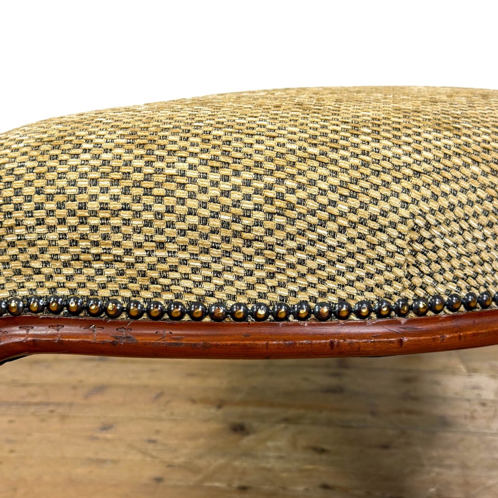 A long curved Victorian upholstered window seat featuring carved mahogany cabriole legs on castors and a patterned textile seat with studding detail. View IV