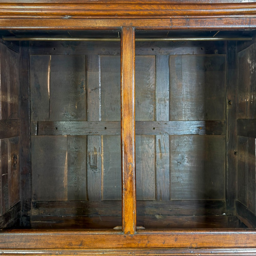 An eighteenth-century two-part Georgian oak livery cupboard with two multi-panelled doors above eight brass-handled drawers. View VI