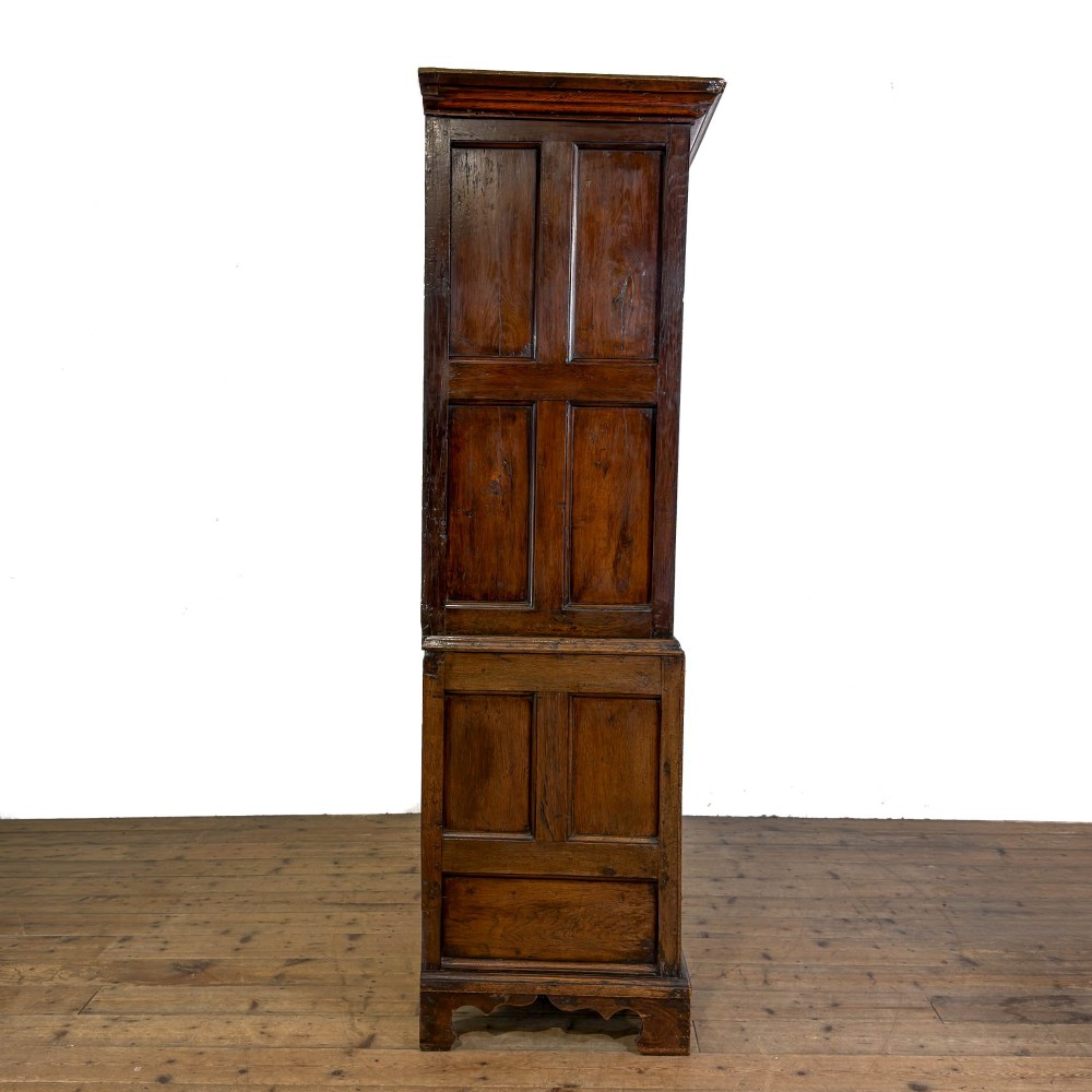 An eighteenth-century two-part Georgian oak livery cupboard with two multi-panelled doors above eight brass-handled drawers. View IX