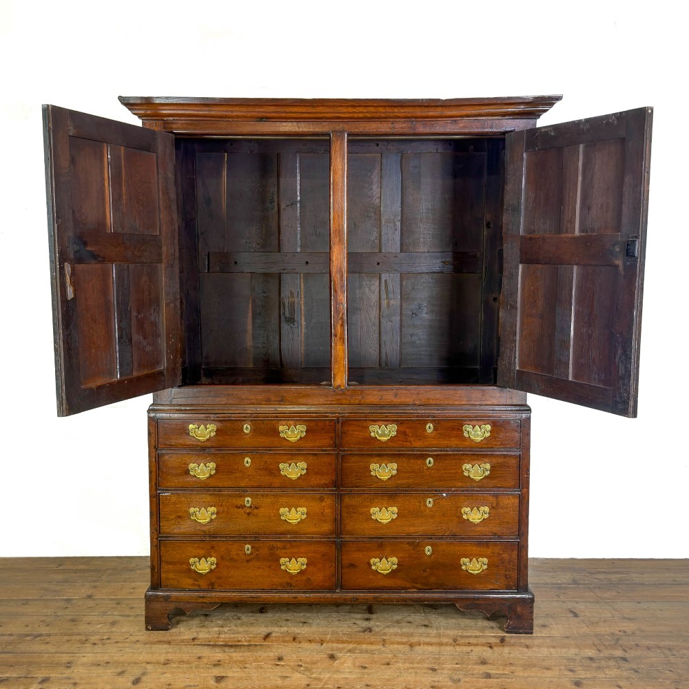 An eighteenth-century two-part Georgian oak livery cupboard with two multi-panelled doors above eight brass-handled drawers. View X