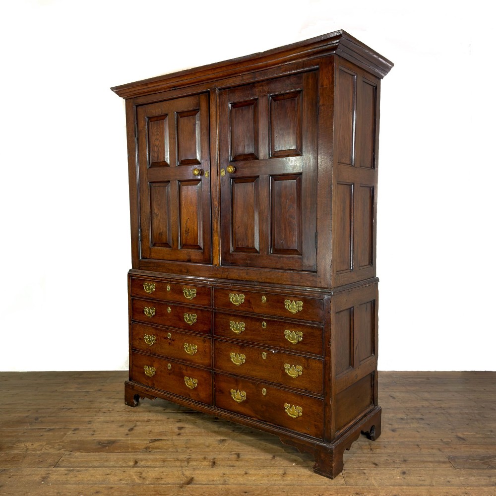 An eighteenth-century two-part Georgian oak livery cupboard with two multi-panelled doors above eight brass-handled drawers. View XII