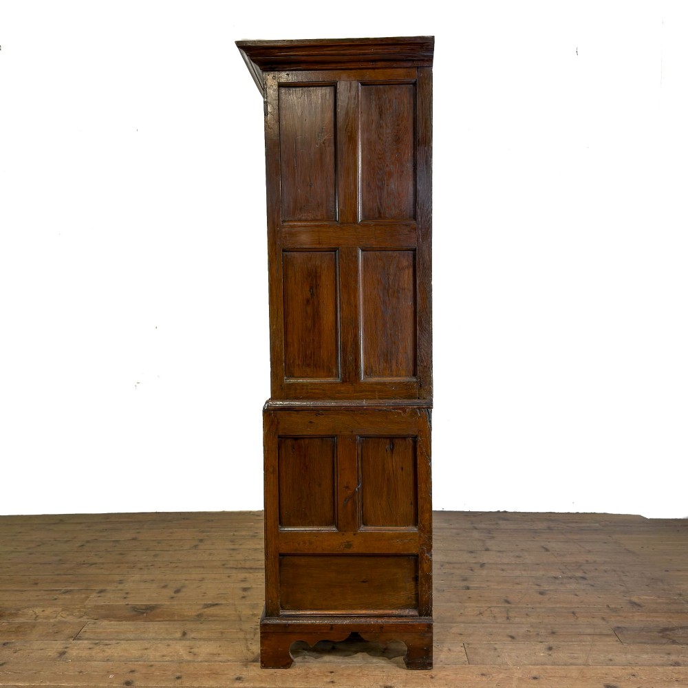 An eighteenth-century two-part Georgian oak livery cupboard with two multi-panelled doors above eight brass-handled drawers. View XIII