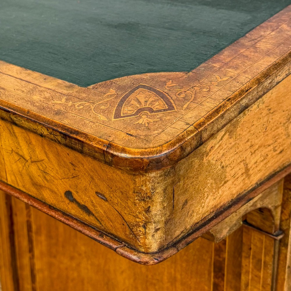 A Victorian burr walnut Davenport desk featuring a green leather writing slope, upper stationer compartment, side drawers, and brass castors. View III