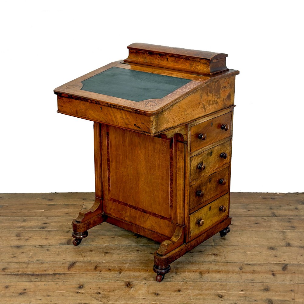 A Victorian burr walnut Davenport desk featuring a green leather writing slope, upper stationer compartment, side drawers, and brass castors. View V