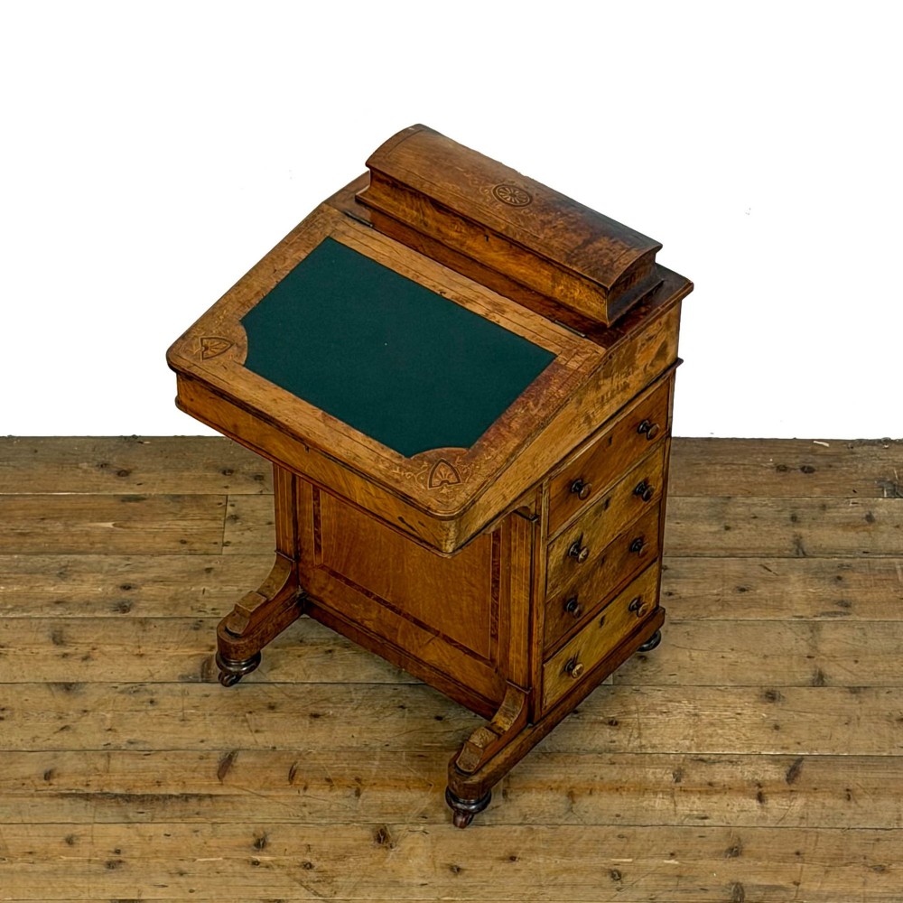 A Victorian burr walnut Davenport desk featuring a green leather writing slope, upper stationer compartment, side drawers, and brass castors. View VII