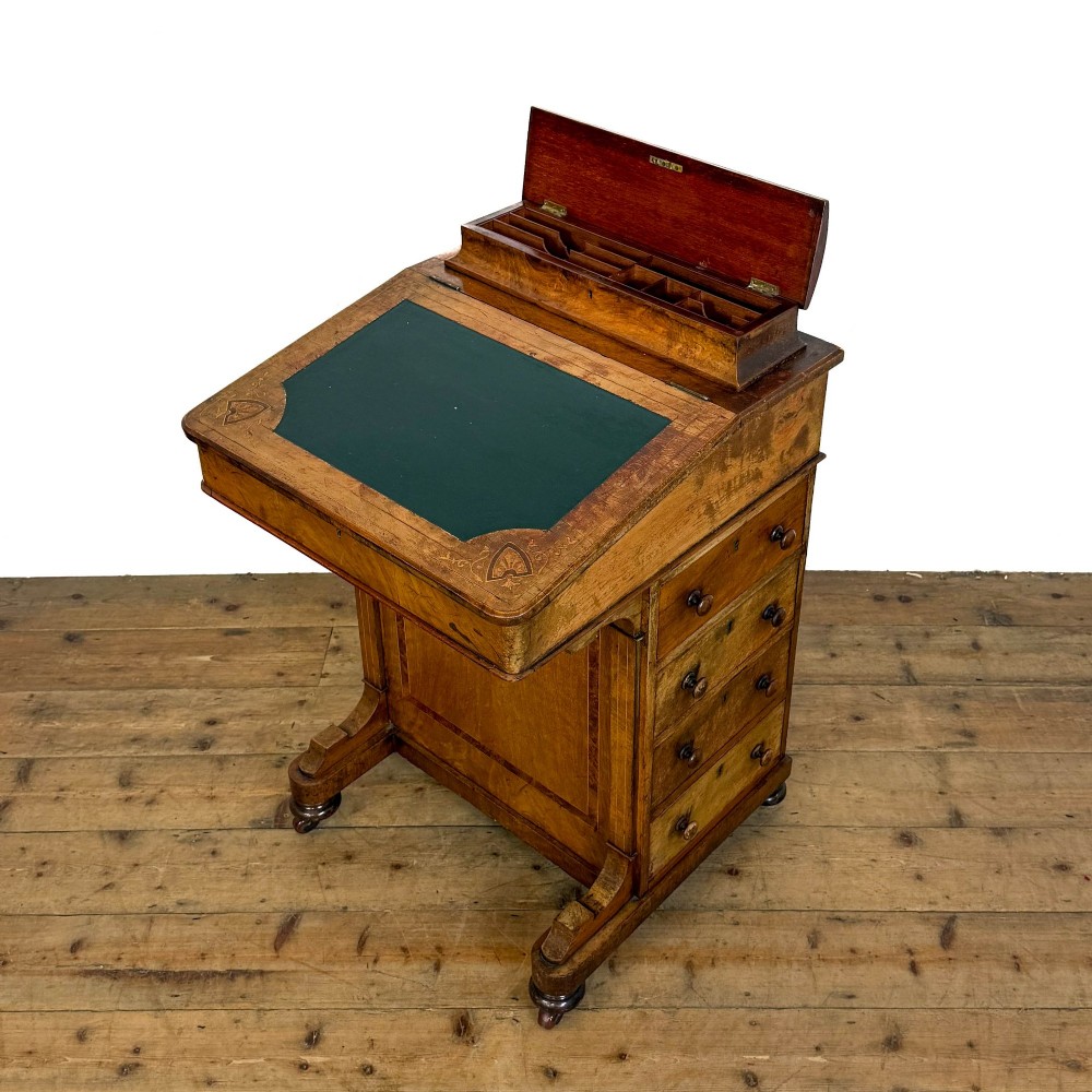 A Victorian burr walnut Davenport desk featuring a green leather writing slope, upper stationer compartment, side drawers, and brass castors. View VIII