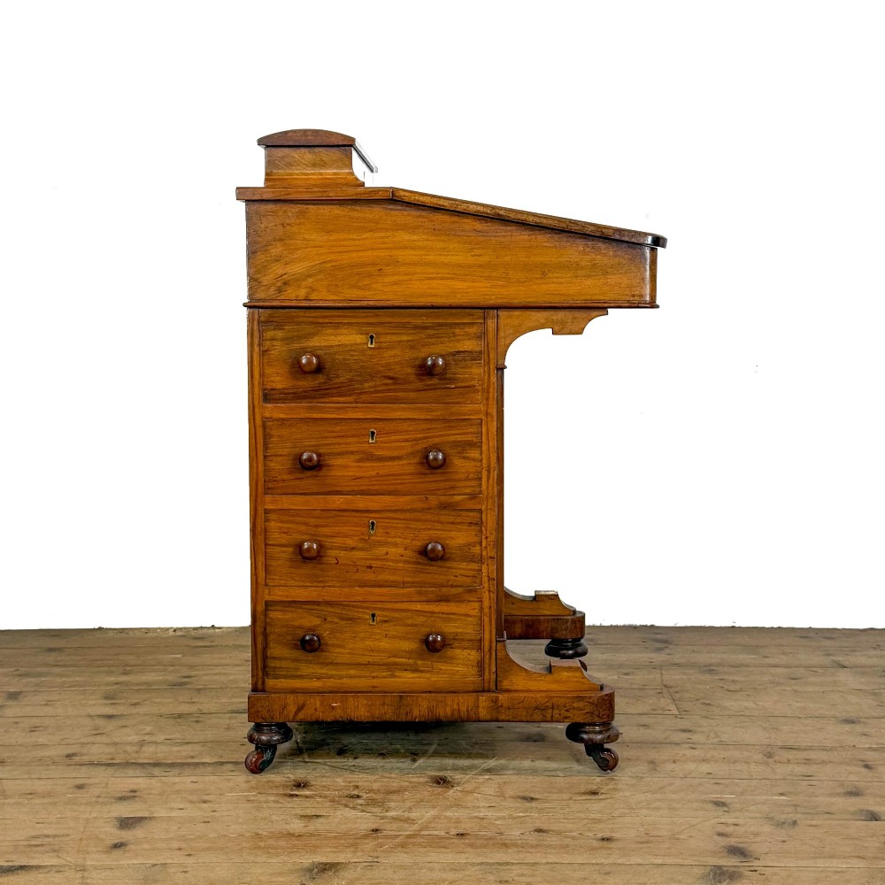 A Victorian burr walnut Davenport desk featuring a green leather writing slope, upper stationer compartment, side drawers, and brass castors. View XII