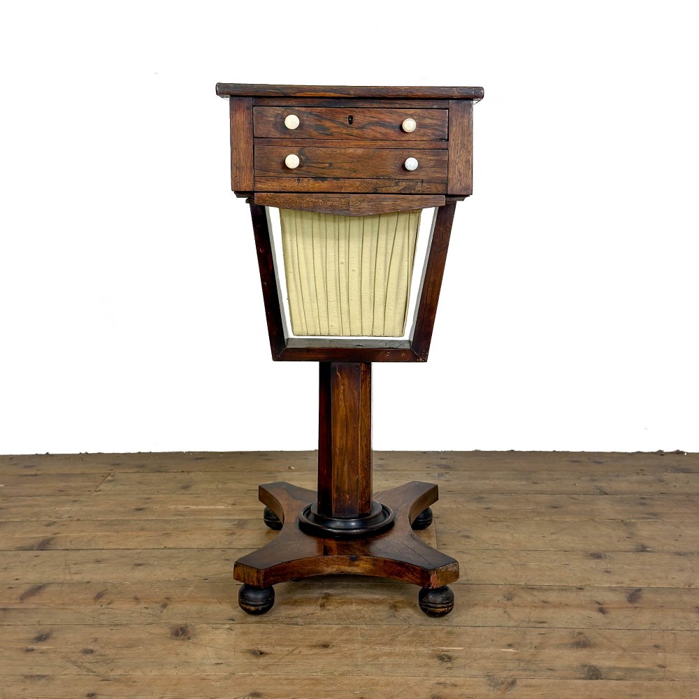 A 19th-century rosewood work table featuring small drawers, a pleated cream fabric basket underneath, a central pedestal support, and a quadruped base. View II