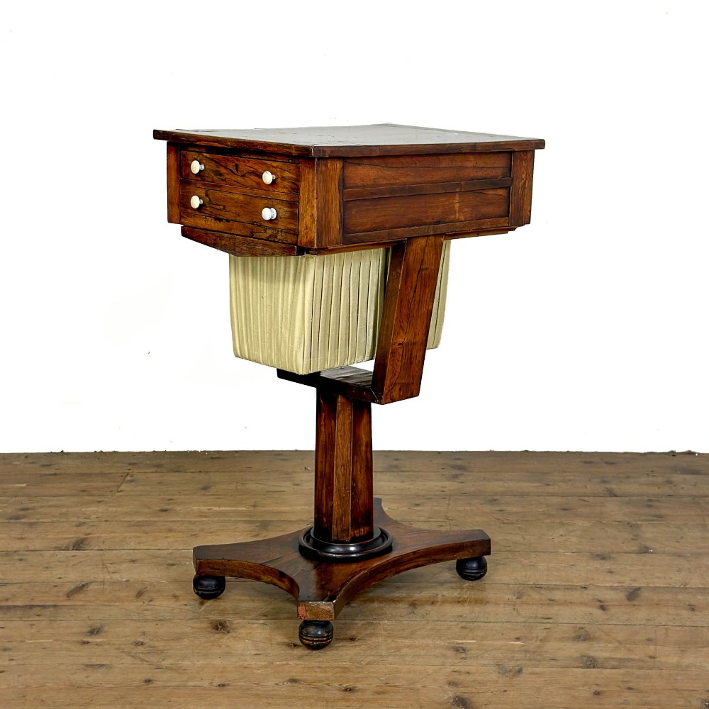 A 19th-century rosewood work table featuring small drawers, a pleated cream fabric basket underneath, a central pedestal support, and a quadruped base. View III