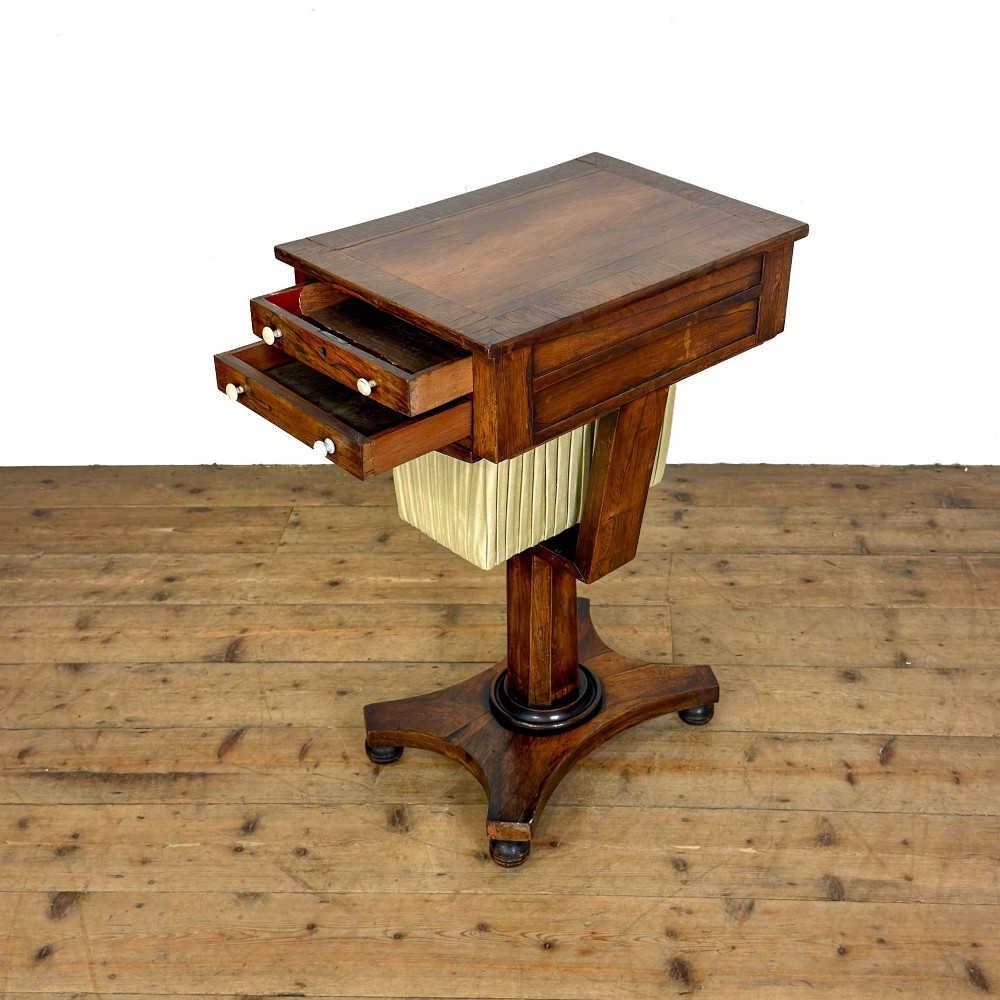 A 19th-century rosewood work table featuring small drawers, a pleated cream fabric basket underneath, a central pedestal support, and a quadruped base. View IV