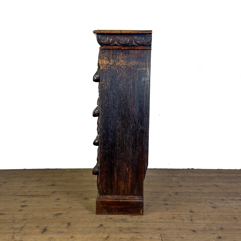 An antique dark oak open bookcase featuring hand-carved foliate detailing along the stiles and a carved upper frieze. View IV