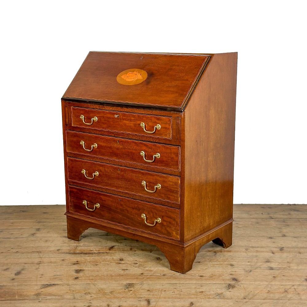 An antique Edwardian mahogany writing bureau featuring a sloping fall-front top with a shell marquetry inlay, situated above four graduating drawers with brass handles on bracket feet. View III