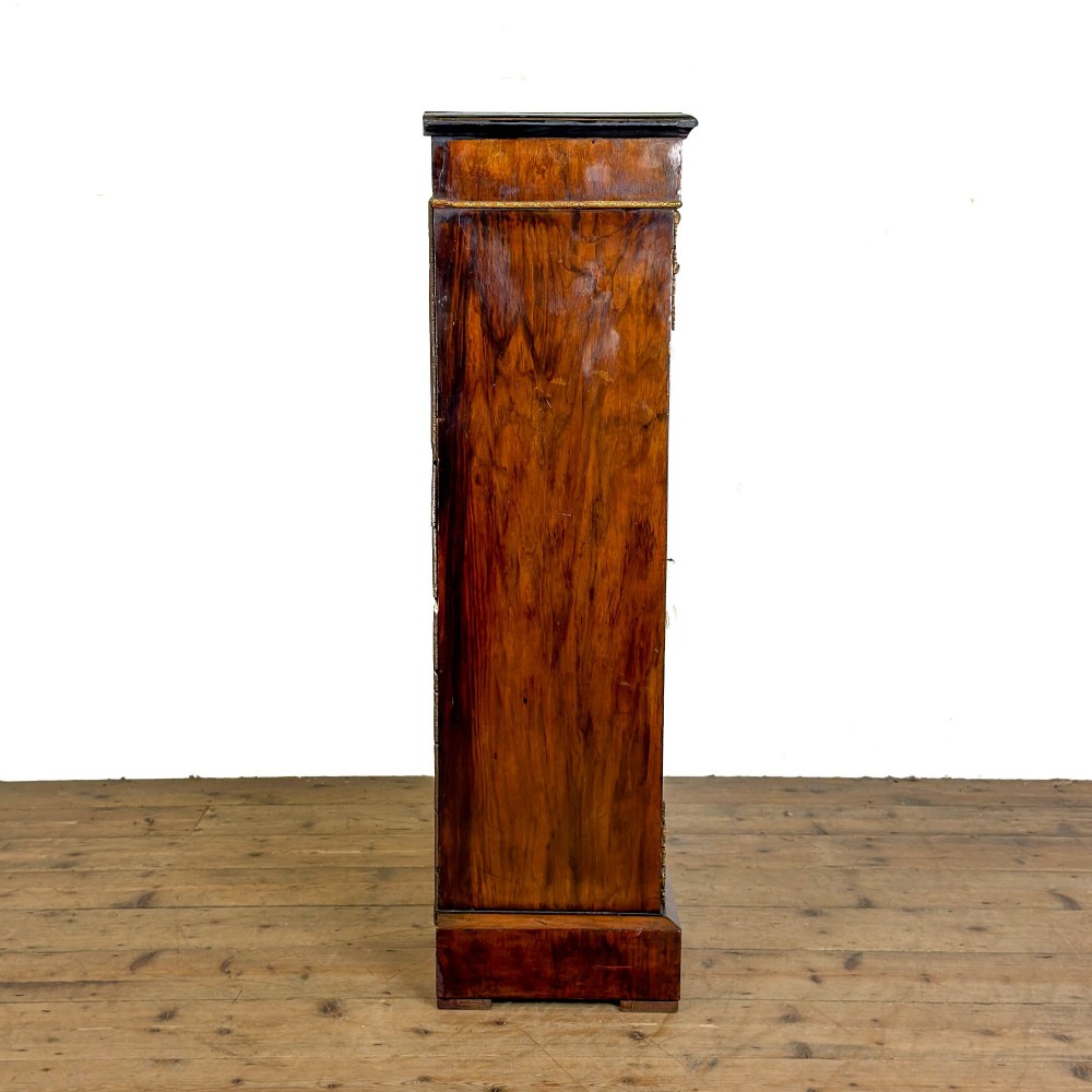 A Victorian inlaid walnut pier cabinet featuring a single glazed door, ormolu brass mounts, floral interior lining, and two interior shelves. View VII
