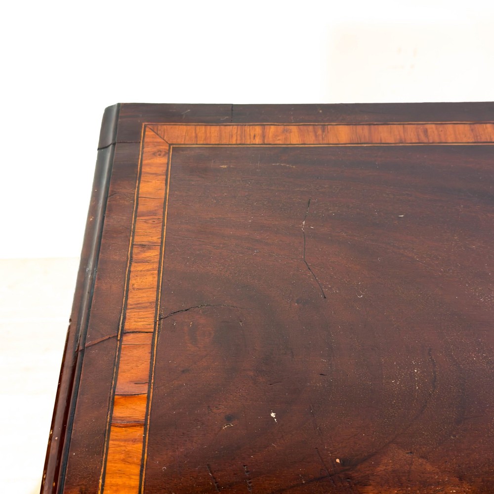 An antique mahogany bachelors chest featuring four crossbanded graduated drawers with brass handles, a brushing slide, and bracket feet. View II