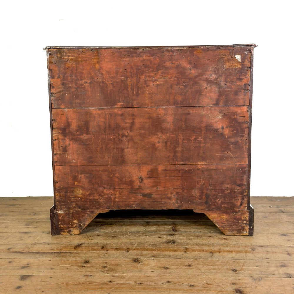 An antique mahogany bachelors chest featuring four crossbanded graduated drawers with brass handles, a brushing slide, and bracket feet. View VI