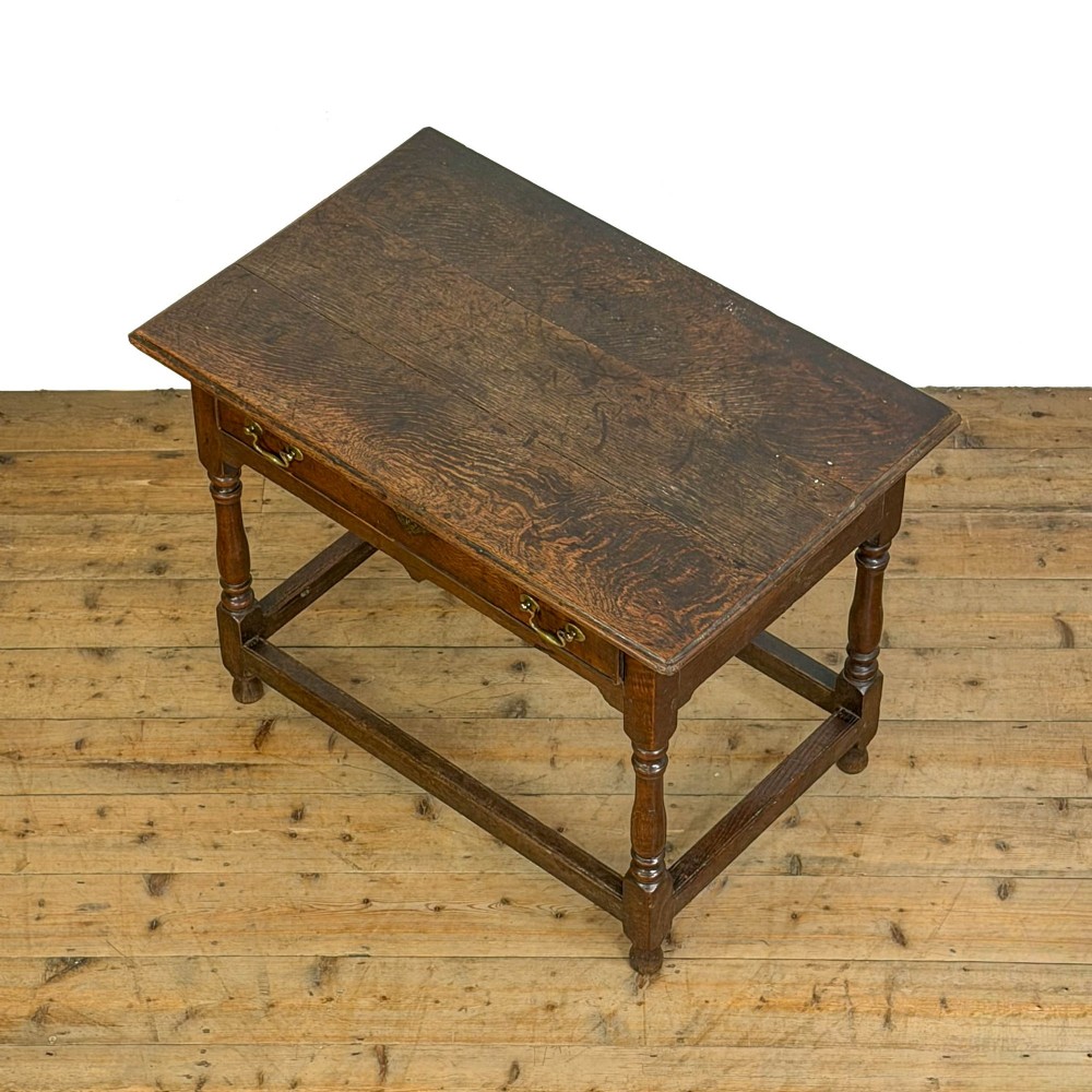An 18th-century oak lowboy side table featuring a single drawer with brass drop handles, turned legs, and a lower box stretcher. View II