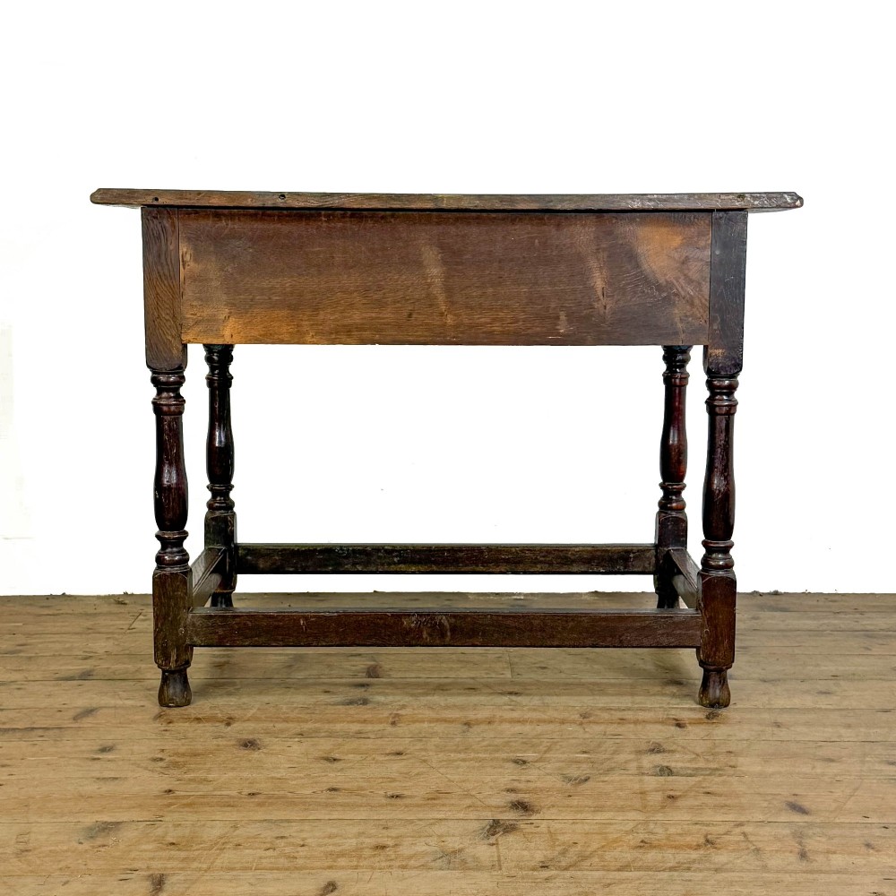 An 18th-century oak lowboy side table featuring a single drawer with brass drop handles, turned legs, and a lower box stretcher. View V