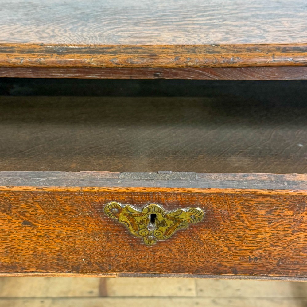 An 18th-century oak lowboy side table featuring a single drawer with brass drop handles, turned legs, and a lower box stretcher. View VIII