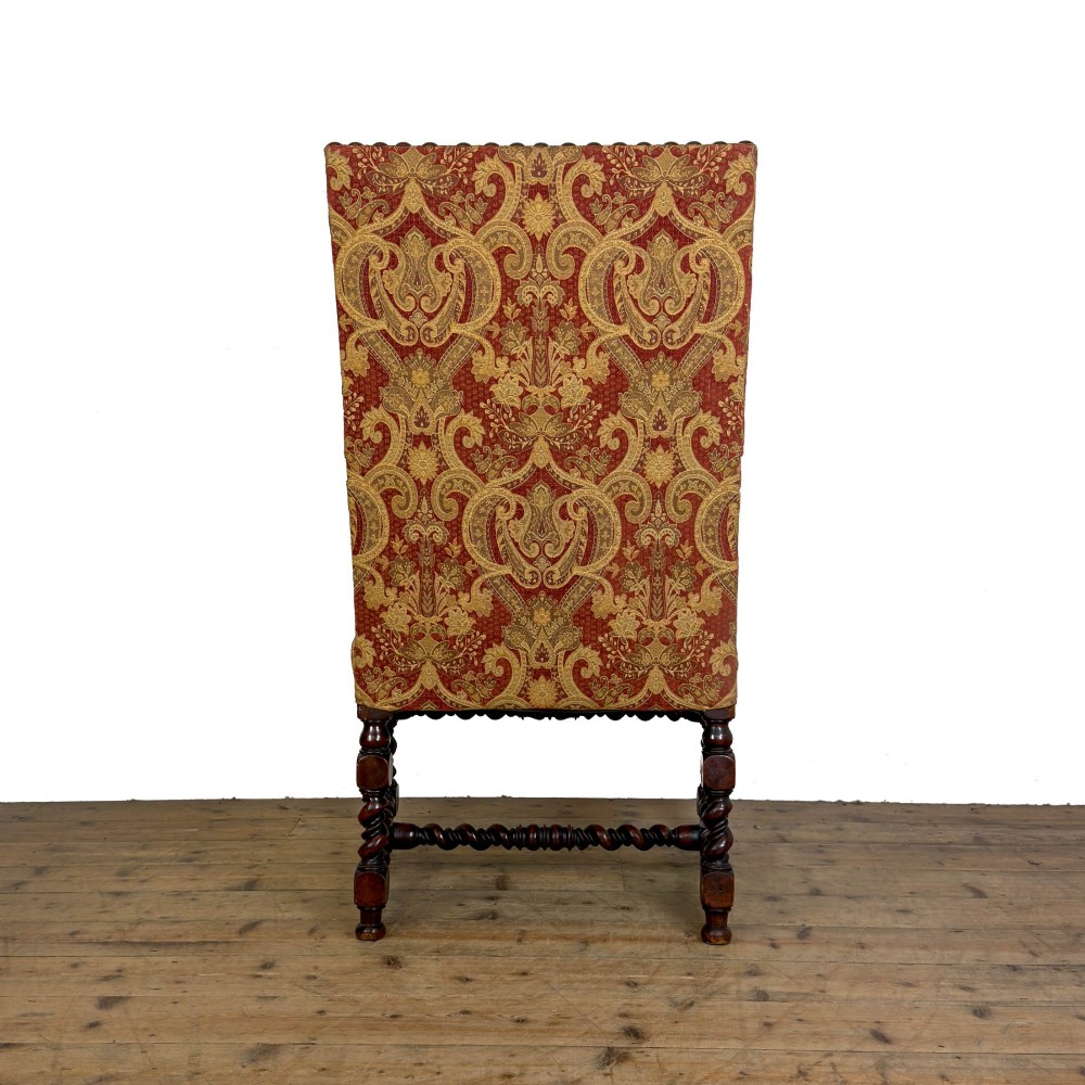 An antique walnut elbow chair featuring barley twist turnings, scrolled arms, and red and gold patterned upholstery with a matching cushion. View III
