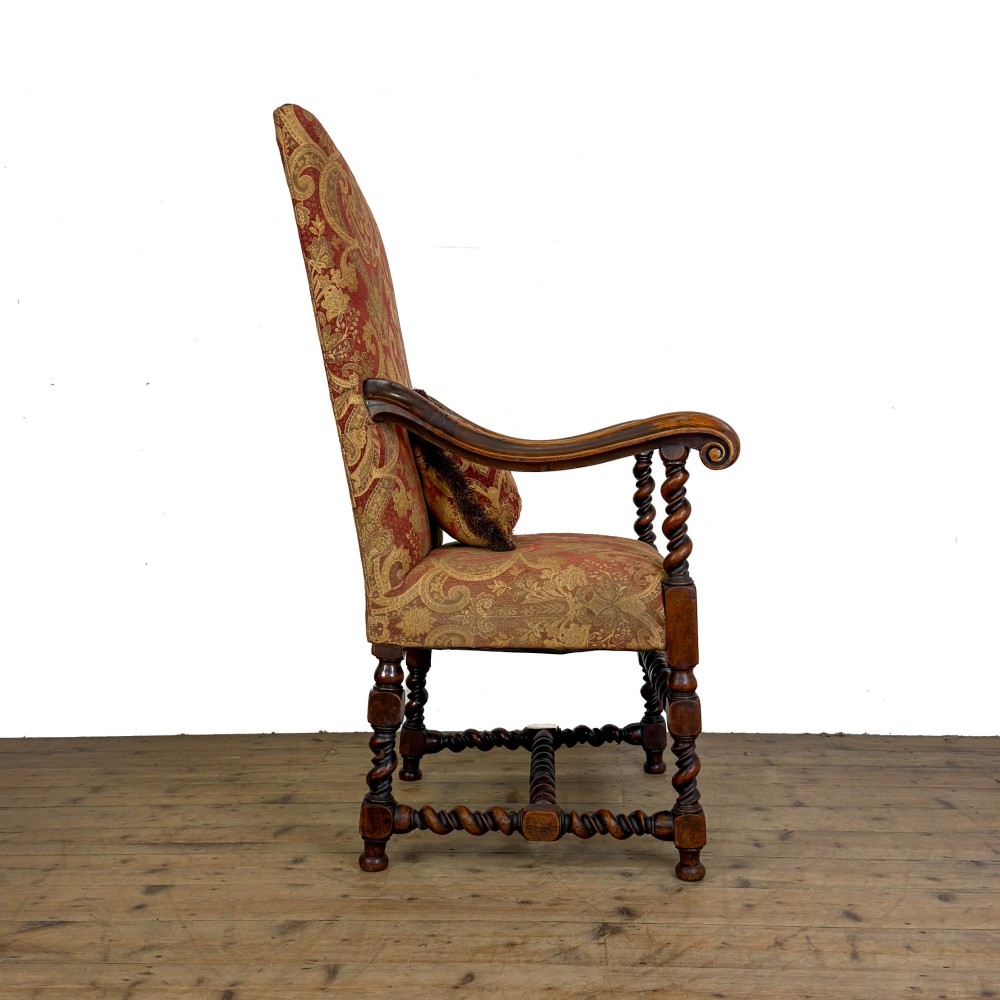 An antique walnut elbow chair featuring barley twist turnings, scrolled arms, and red and gold patterned upholstery with a matching cushion. View IV