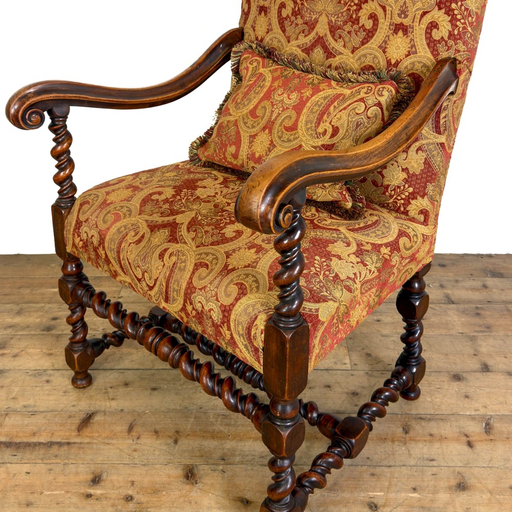 An antique walnut elbow chair featuring barley twist turnings, scrolled arms, and red and gold patterned upholstery with a matching cushion. View VIII