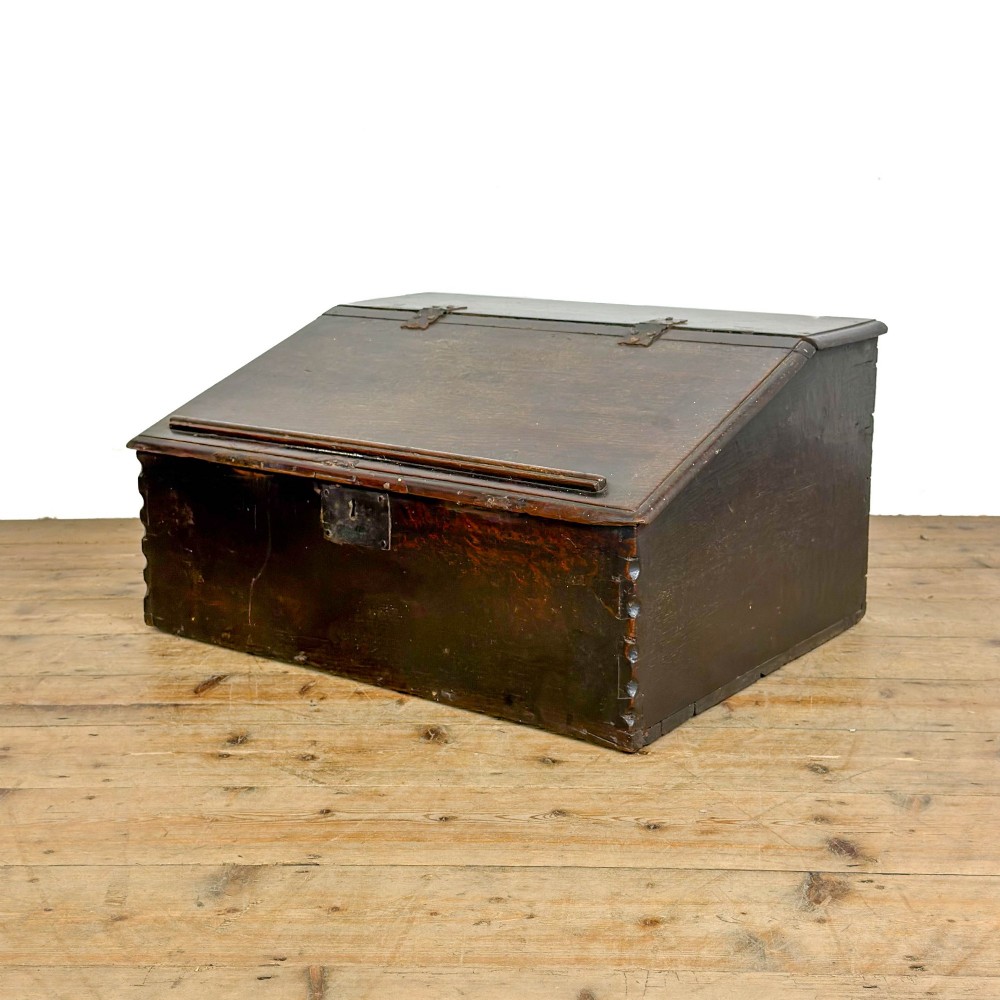 A dark brown oak bible box featuring a sloped hinged lid with a wooden rest ledge and an iron lockplate. View III