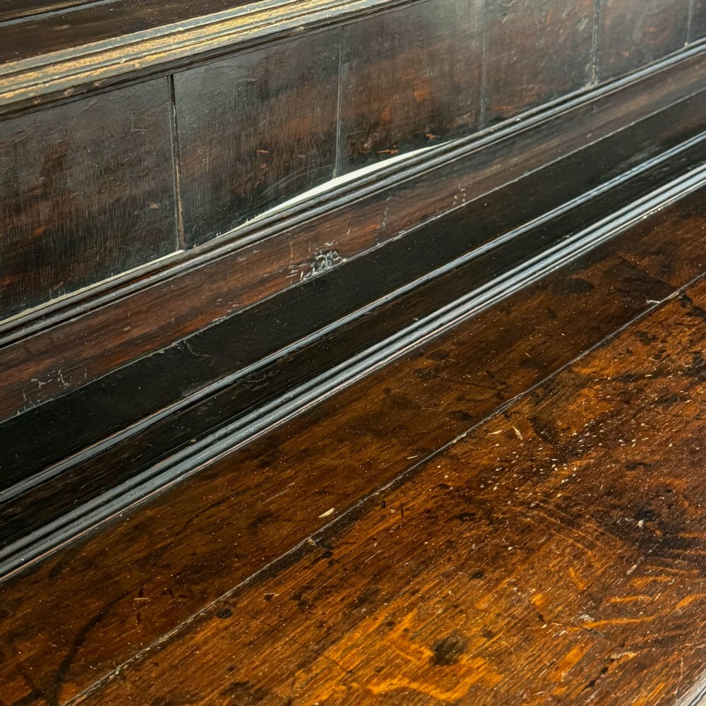 A dark oak 19th-century Welsh dresser featuring a three-tier open plate rack with a scalloped canopy above three drawers and an open pot board lower section. View V