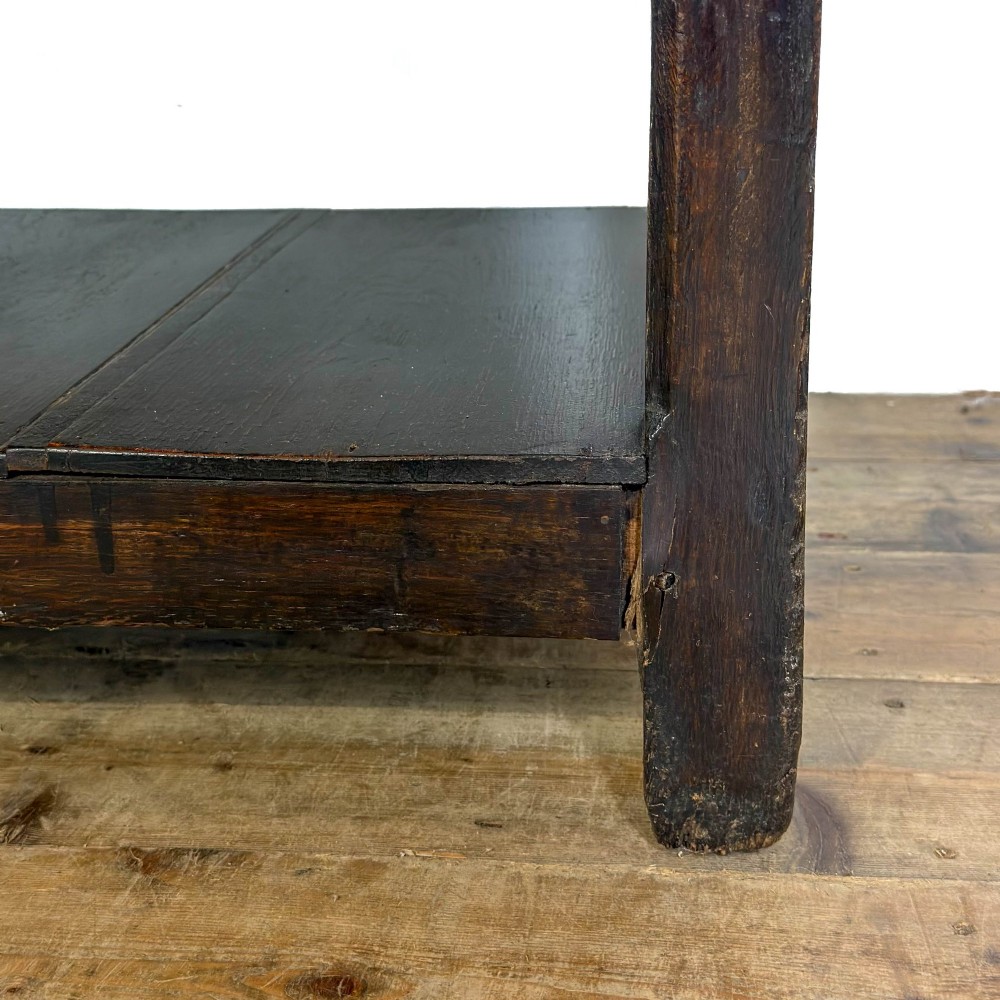A dark oak 19th-century Welsh dresser featuring a three-tier open plate rack with a scalloped canopy above three drawers and an open pot board lower section. View VIII