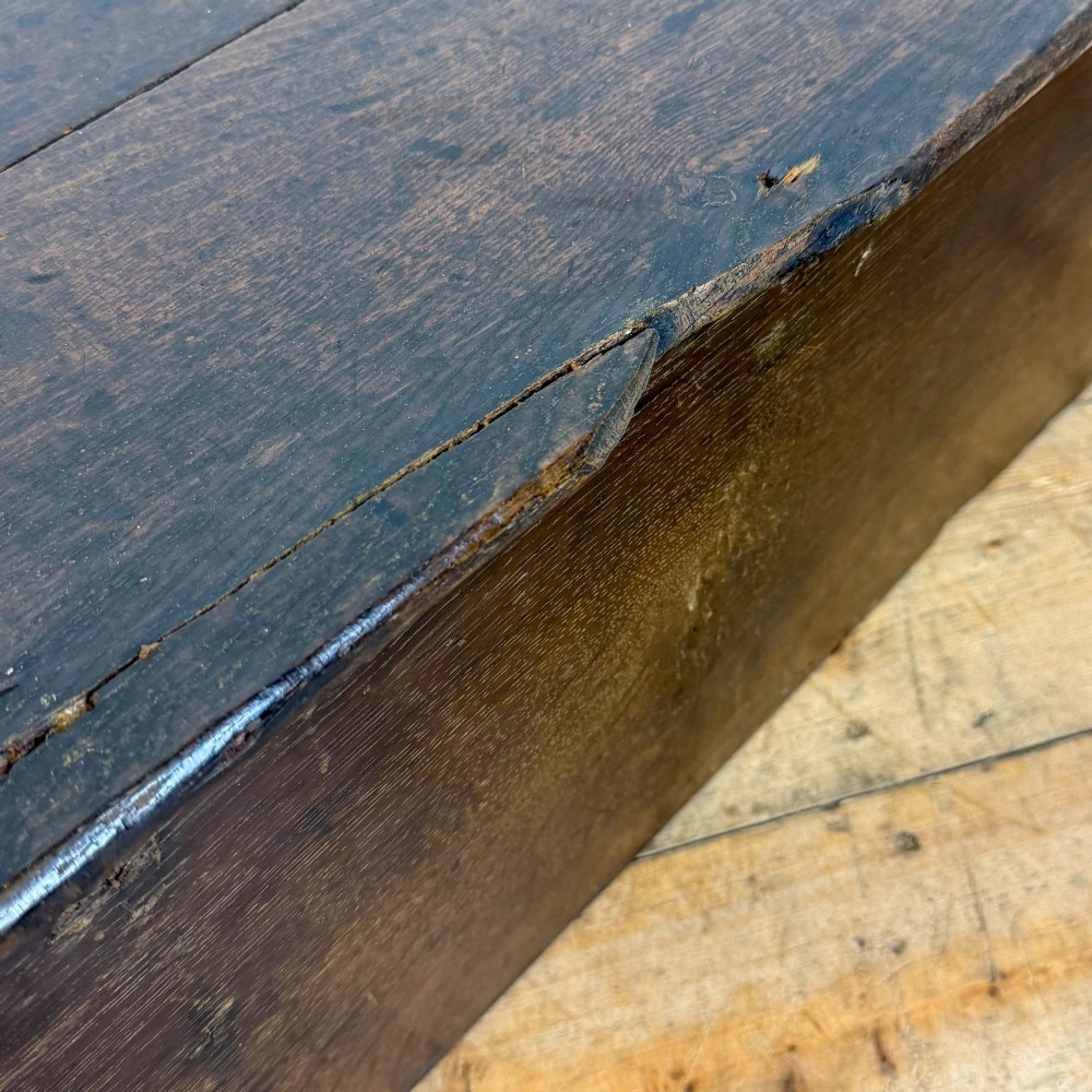 An 18th-century dark oak bible box featuring a hinged top lid, carved initials flanking a central iron lock plate, and a rectangular timber body. View II
