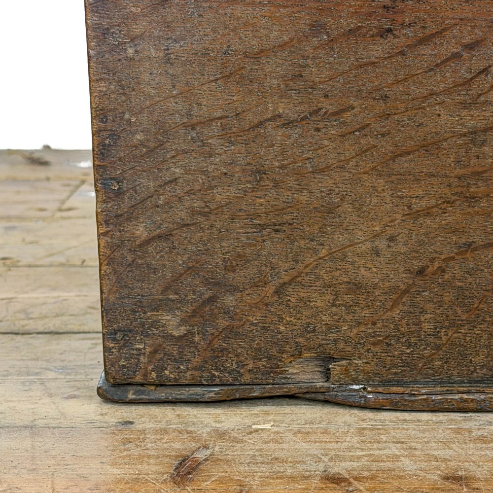 An 18th-century dark oak bible box featuring a hinged top lid, carved initials flanking a central iron lock plate, and a rectangular timber body. View III