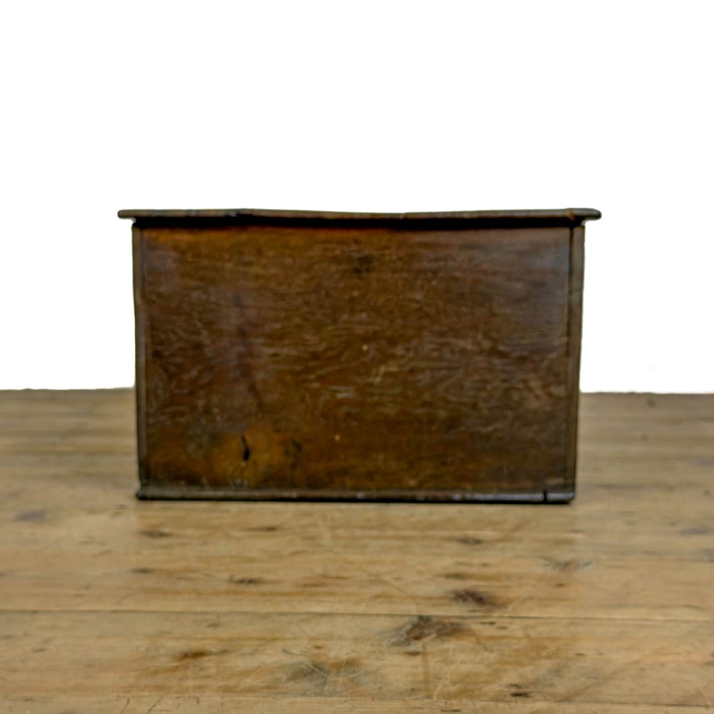 An 18th-century dark oak bible box featuring a hinged top lid, carved initials flanking a central iron lock plate, and a rectangular timber body. View IV