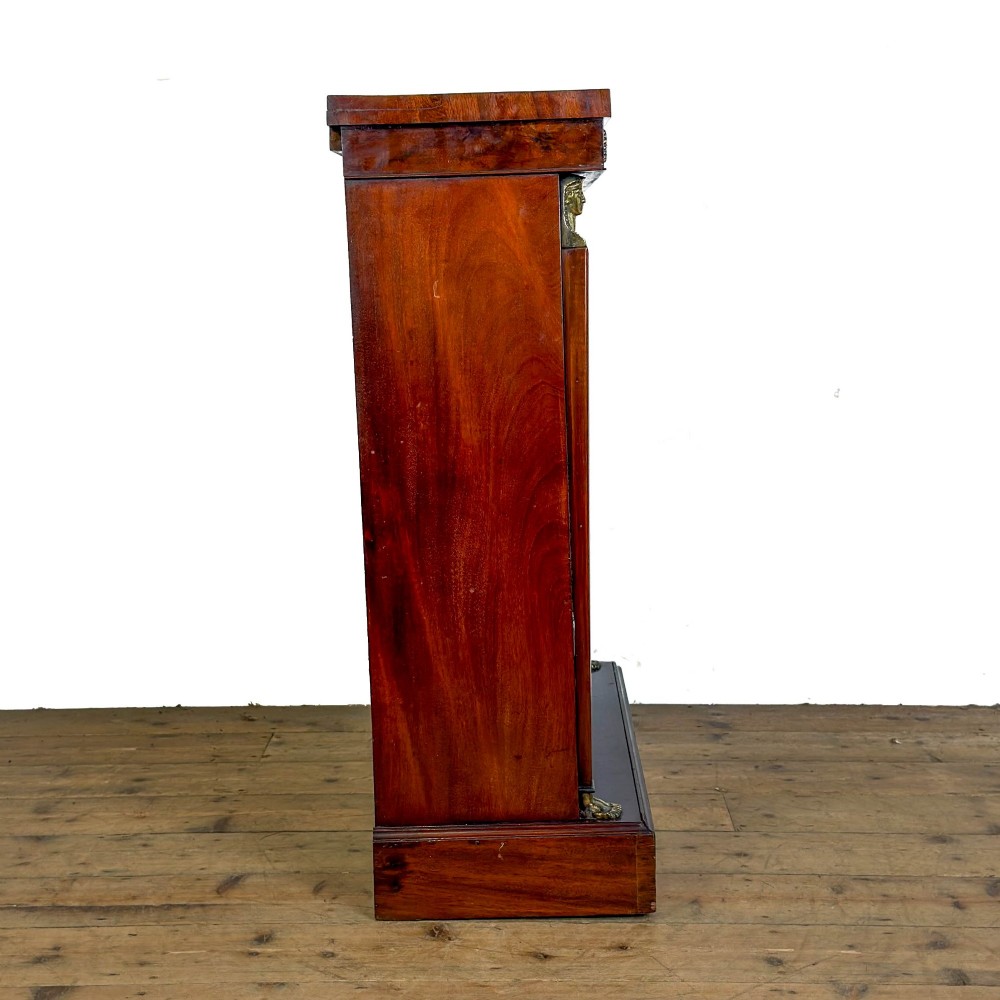 An antique Egyptian Revival mahogany open bookcase featuring fluted pilasters topped with cast brass sphinx heads, adjustable wooden shelves, and a plinth base. View II