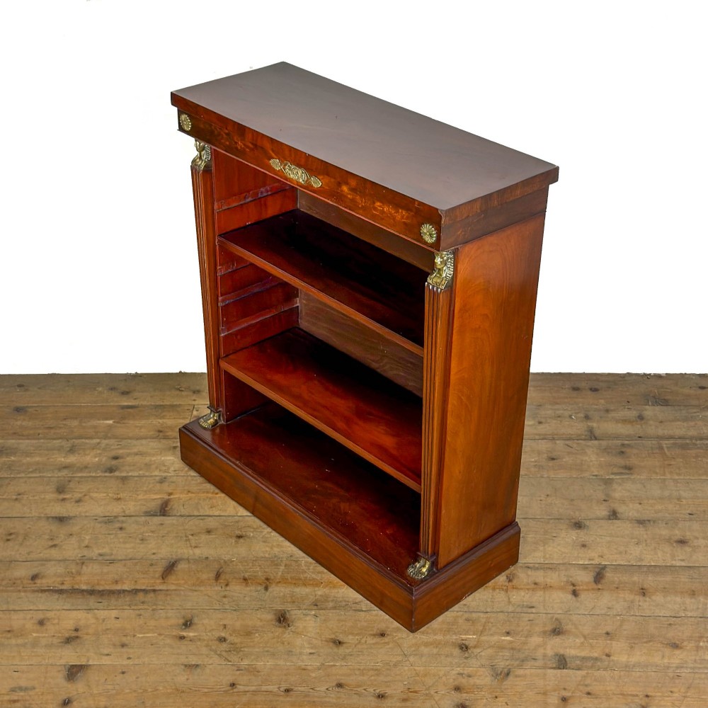 An antique Egyptian Revival mahogany open bookcase featuring fluted pilasters topped with cast brass sphinx heads, adjustable wooden shelves, and a plinth base. View III