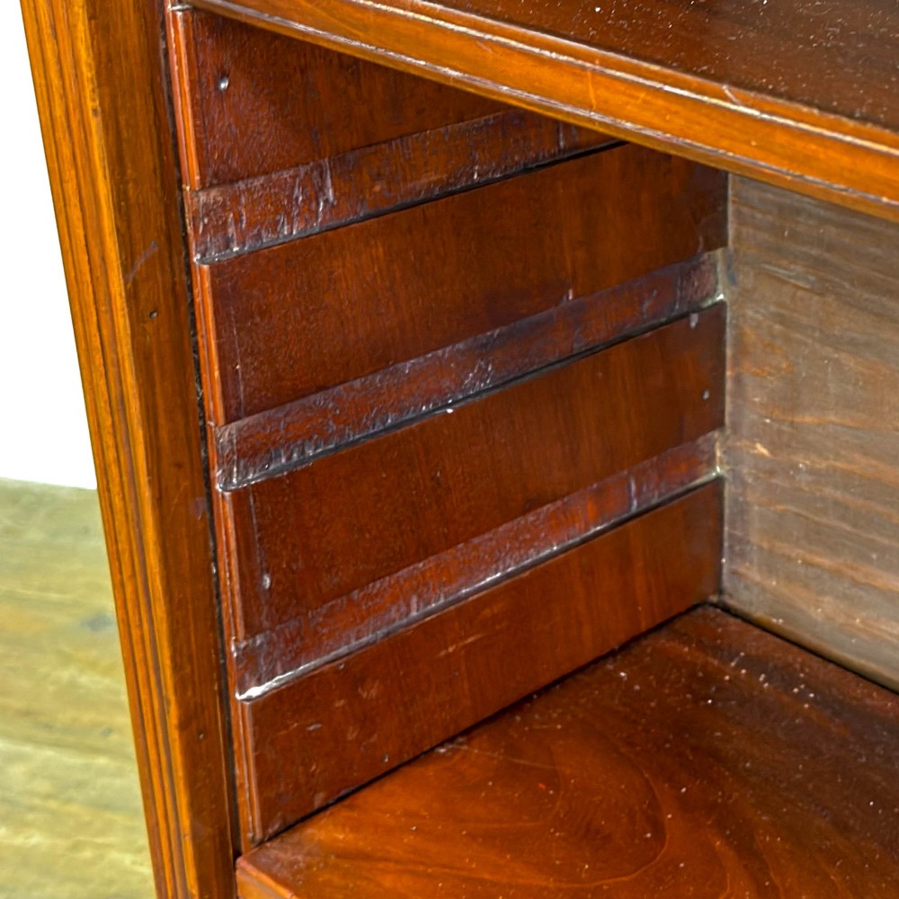 An antique Egyptian Revival mahogany open bookcase featuring fluted pilasters topped with cast brass sphinx heads, adjustable wooden shelves, and a plinth base. View V