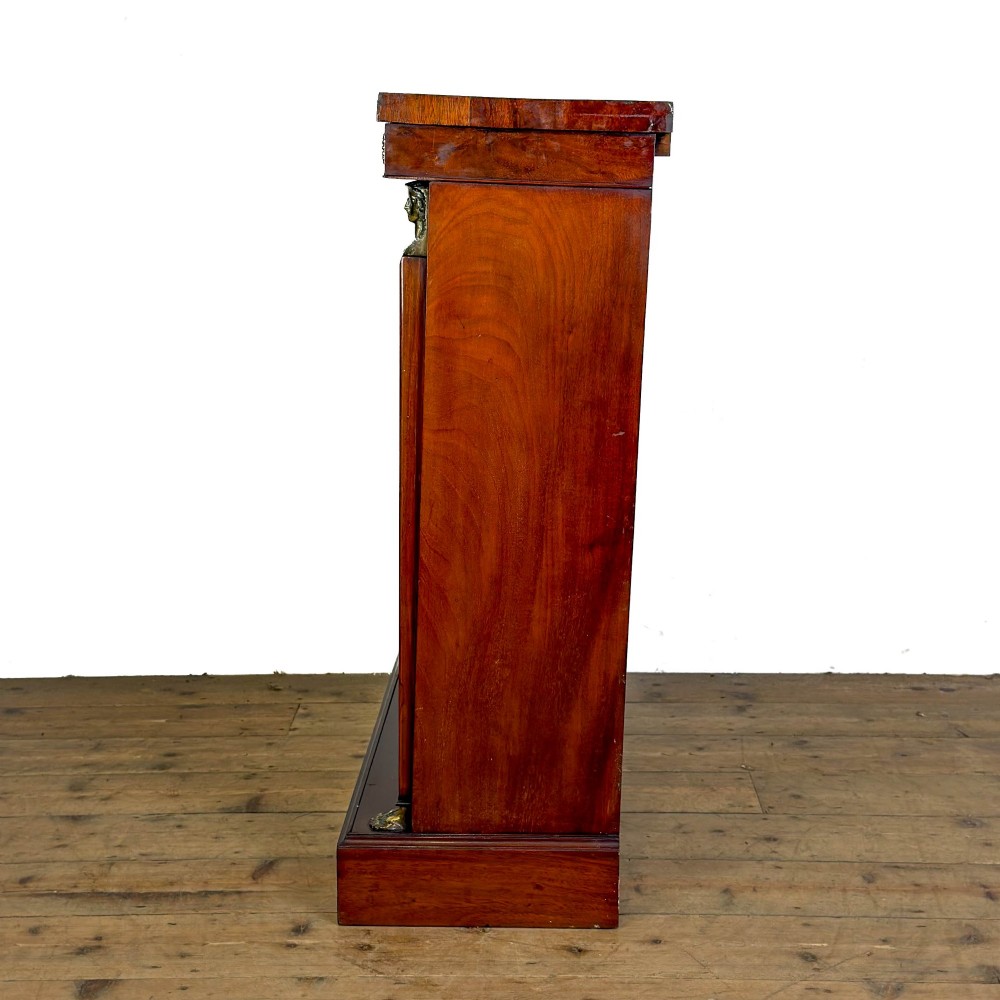 An antique Egyptian Revival mahogany open bookcase featuring fluted pilasters topped with cast brass sphinx heads, adjustable wooden shelves, and a plinth base. View VII