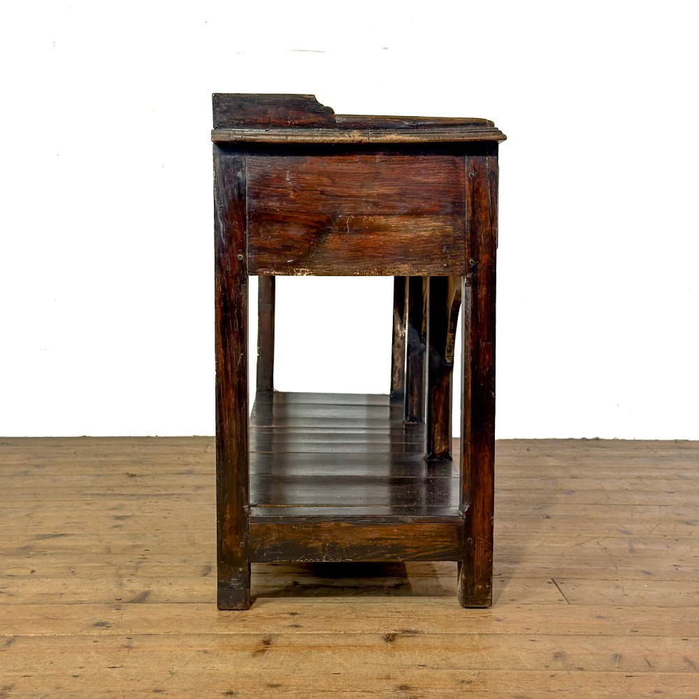 A 19th-century dark oak dresser base featuring three upper drawers with brass oval handles, three decorative arched aprons, and a low potboard shelf. View III