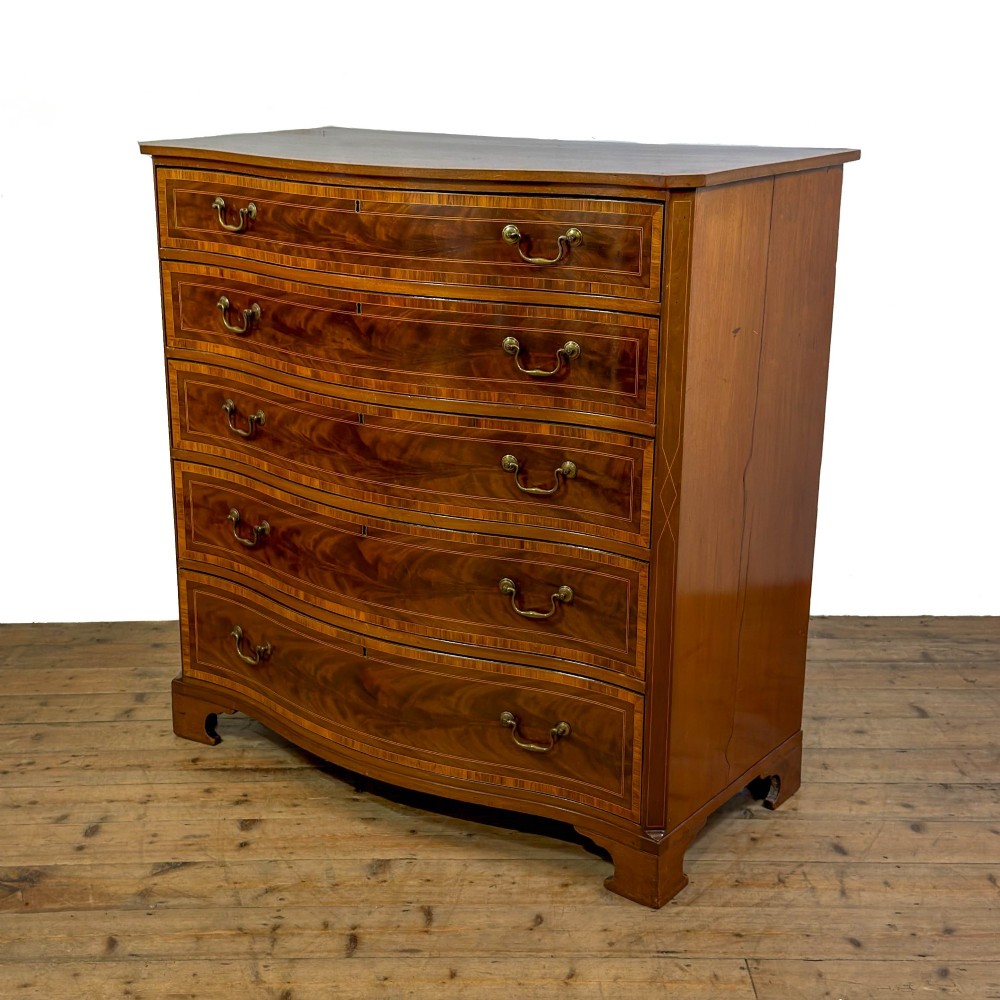 An antique mahogany serpentine chest featuring five graduated drawers with brass swan-neck handles and crossbanded inlay. View VII