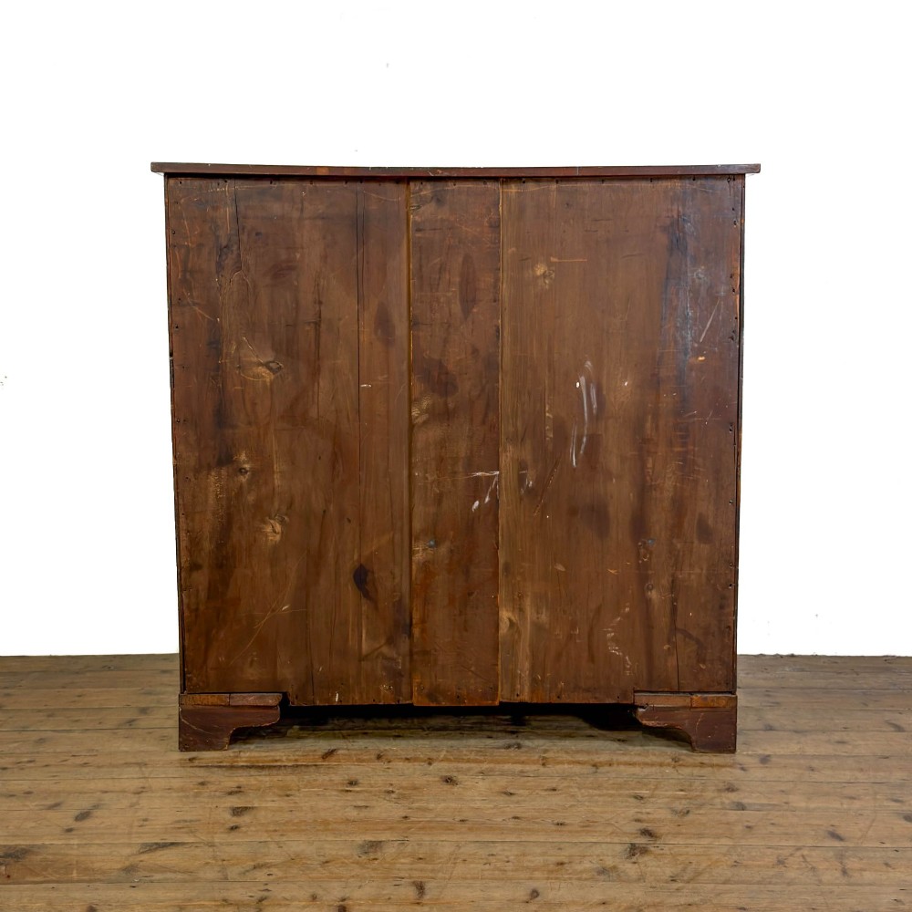 An antique mahogany serpentine chest featuring five graduated drawers with brass swan-neck handles and crossbanded inlay. View IX