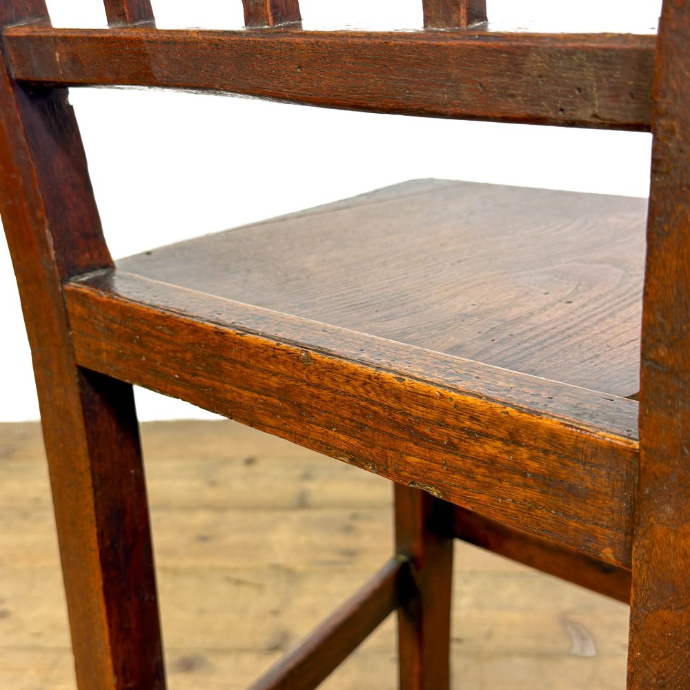 A set of four dark oak dining chairs with vertical slat backrests, solid timber seats, and straight square legs joined by stretchers. View IV