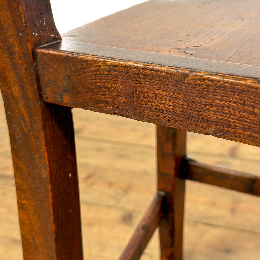 A set of four dark oak dining chairs with vertical slat backrests, solid timber seats, and straight square legs joined by stretchers. View VI