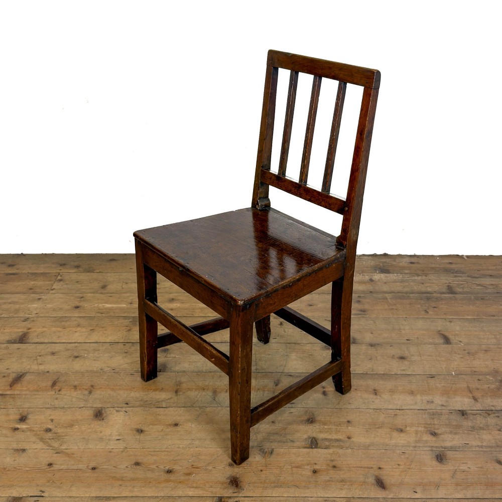 A set of four dark oak dining chairs with vertical slat backrests, solid timber seats, and straight square legs joined by stretchers. View VII
