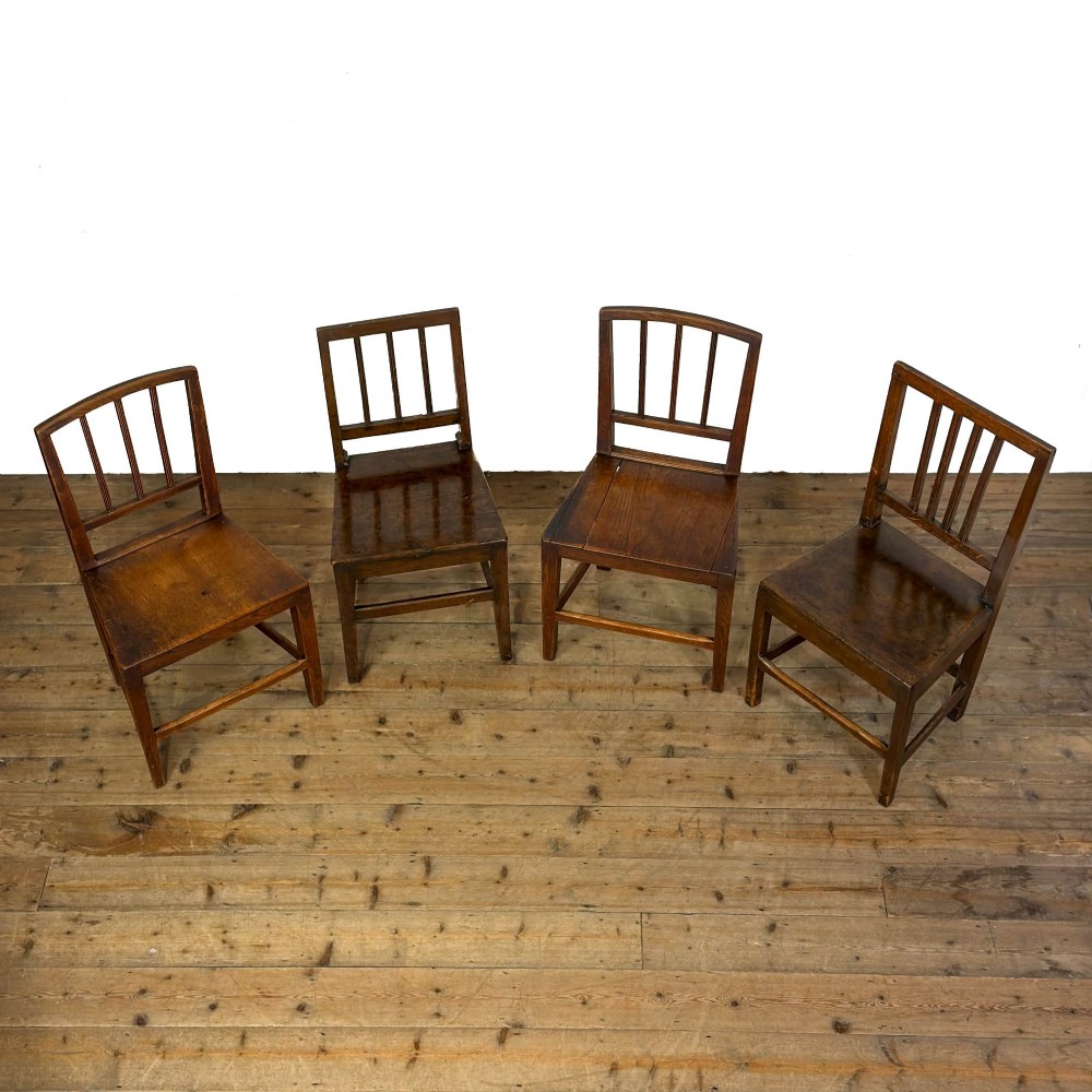 A set of four dark oak dining chairs with vertical slat backrests, solid timber seats, and straight square legs joined by stretchers. View XII