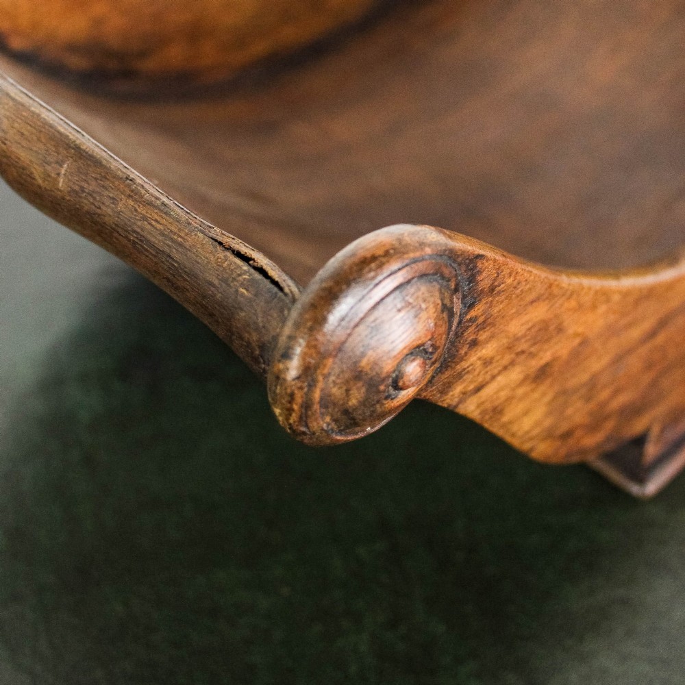 A Georgian mahogany cheese coaster featuring a curved trough with turned scroll ends resting on a rectangular base. View XII