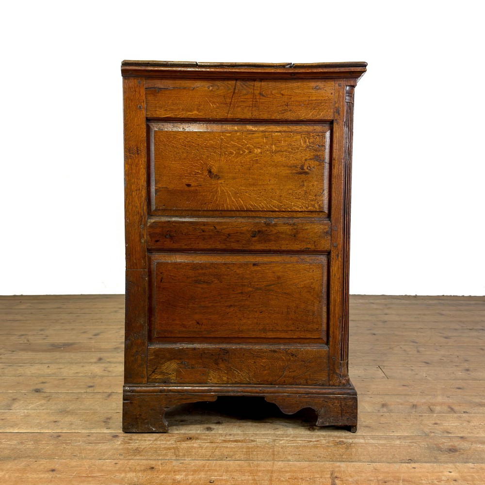 An antique Georgian oak dresser base with multiple drawers, fielded panel cupboard doors, and brass swan-neck handles on a bracket feet base. View XII