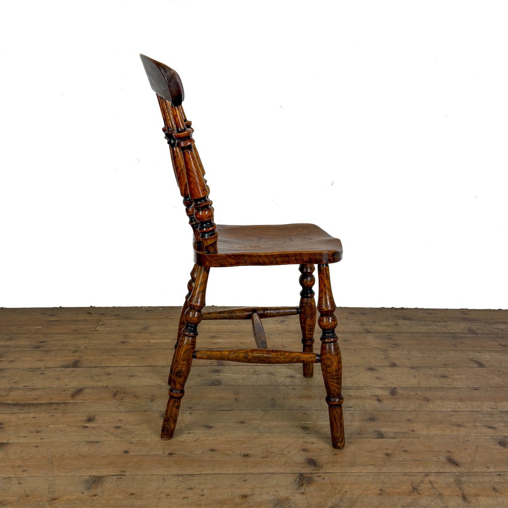 A matching set of four wooden farmhouse kitchen chairs featuring turned spindle backs, contoured seats, and turned legs connected by H-stretchers. View VI