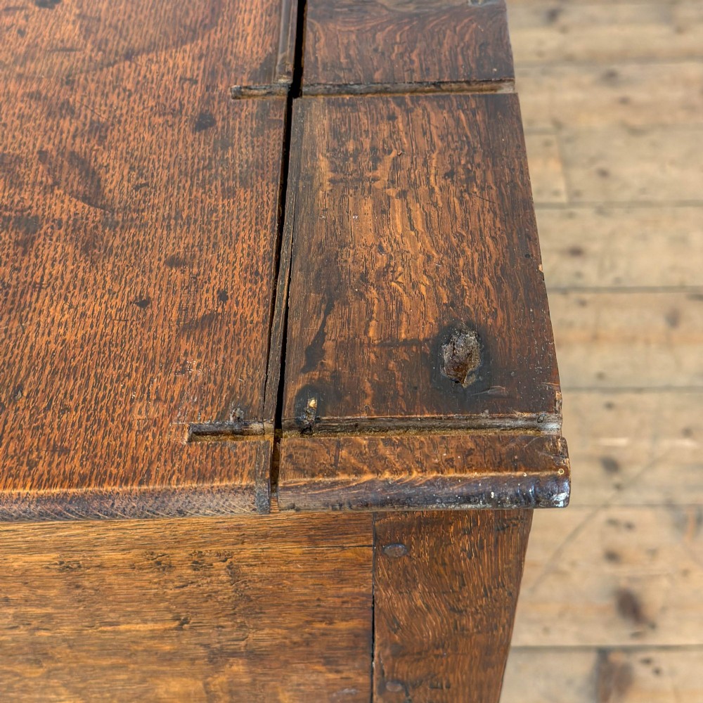 An antique oak dresser base featuring two drawers with brass backplate handles, shaped lower aprons, turned front legs, and an open potboard shelf. View VI
