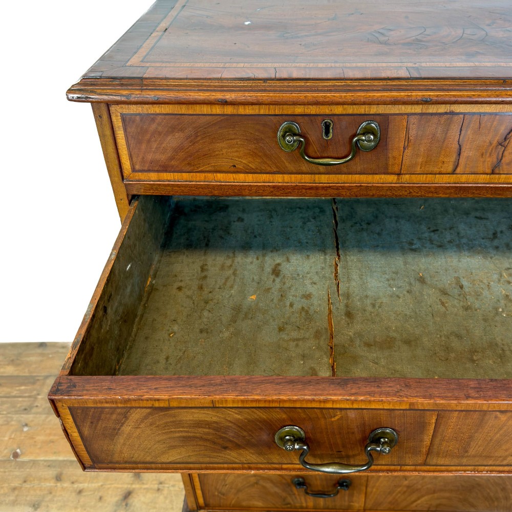 A Georgian mahogany chest of drawers featuring two short over four long graduated drawers with brass swan-neck handles and bracket feet. View III