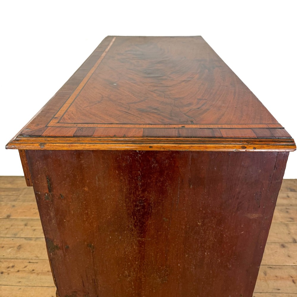 A Georgian mahogany chest of drawers featuring two short over four long graduated drawers with brass swan-neck handles and bracket feet. View VII